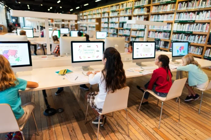 children using computers in library